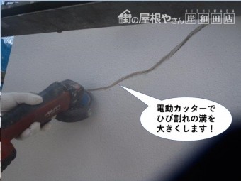 岸和田市の外壁に電動カッターでひび割れ面を広げます
