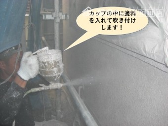 岸和田市の塗装でカップの中に塗料を入れて吹き付けします