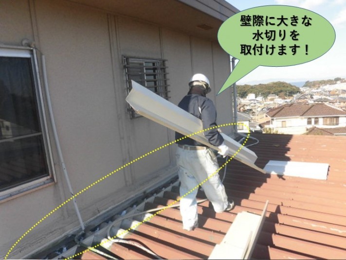 泉南群岬町の壁際に大きな水切りを取付けます
