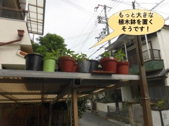 岸和田市のカーポートの屋根に大きな植木鉢を置きます