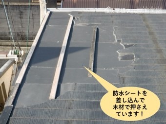 熊取町の屋根に防水シートを差し込んで木材で押さえています