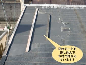 熊取町の屋根に防水シートを差し込んで木材で押さえています