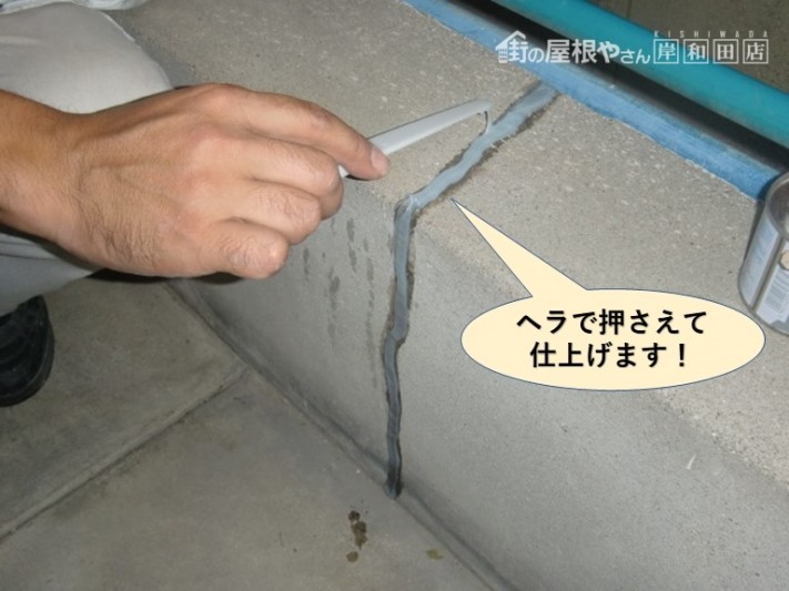 岸和田市のベランダのコーキングをヘラで押さえて仕上げます