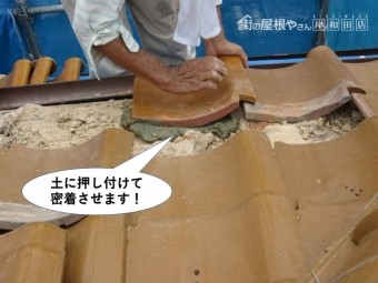 熊取町の軒先瓦を土に押し付けて密着させます