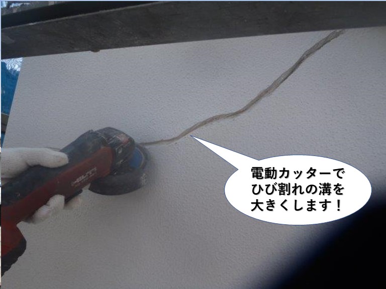 岸和田市の外壁に電動カッターでひび割れ面を広げます