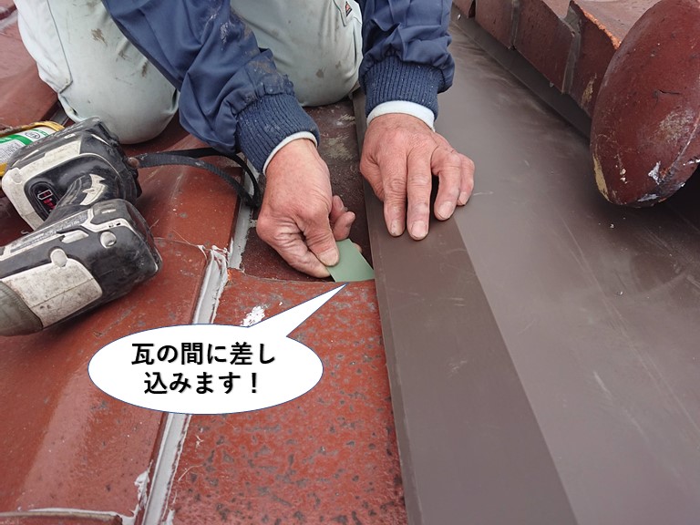 熊取町で細長い板金を瓦の間に差し込みます