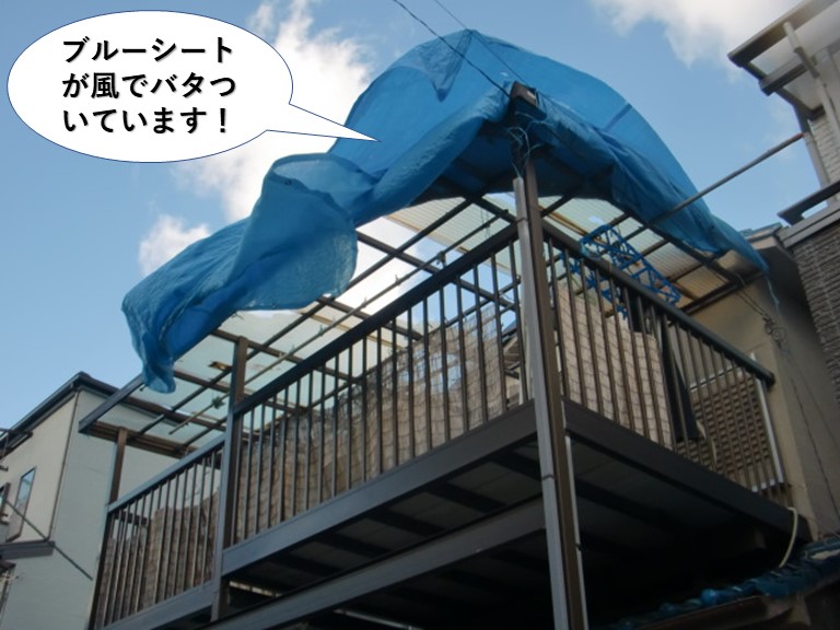 泉佐野市のテラスを養生しているブルーシートが風でバタ付いています