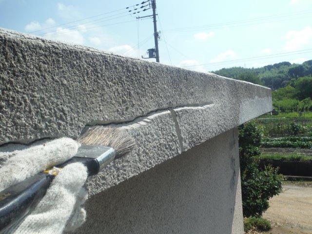 岸和田市包近町の屋根のクラックの溝を刷毛で清掃