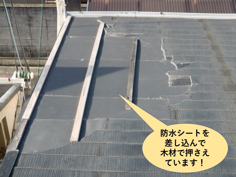熊取町の屋根に防水シートを差し込んで木材で押さえています