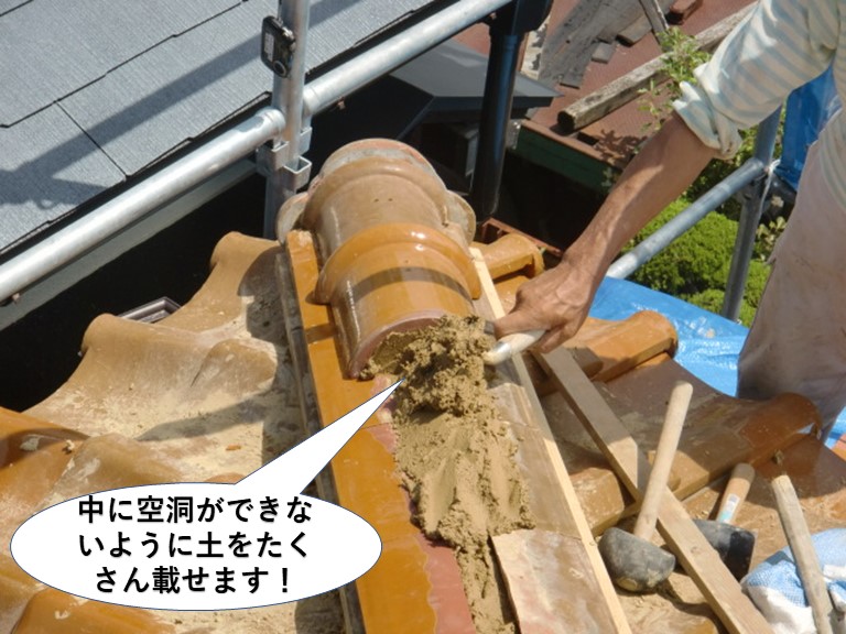 熊取町の冠瓦の中に空洞ができないように土をたくさん載せます