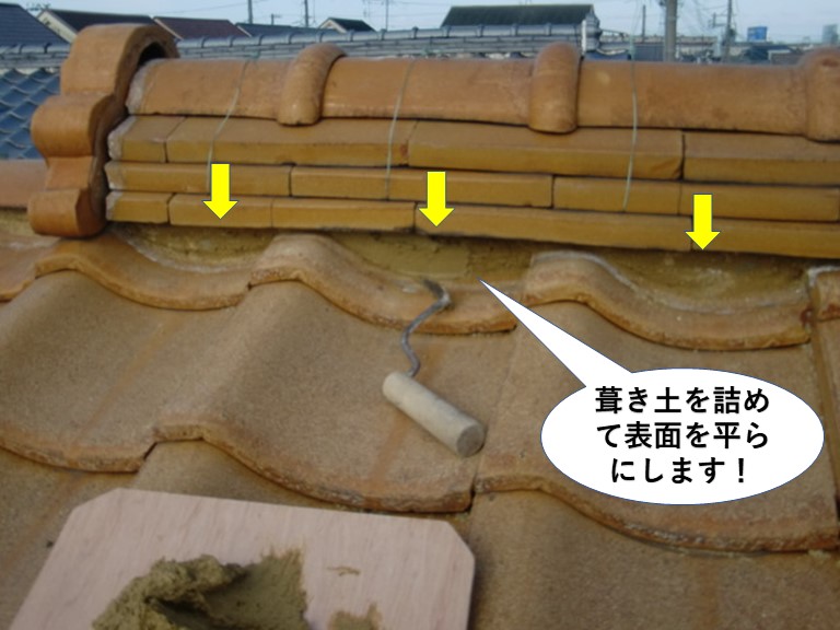 熊取町の棟に葺き土を詰めて平らにします