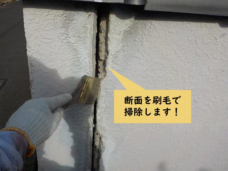 岸和田市の塀のひび割れの断面を刷毛で掃除します