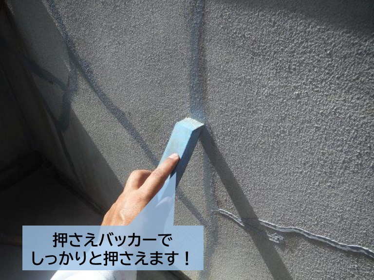 泉大津市のベランダの手すり壁のひび割れに充填したシーリングを押さえます