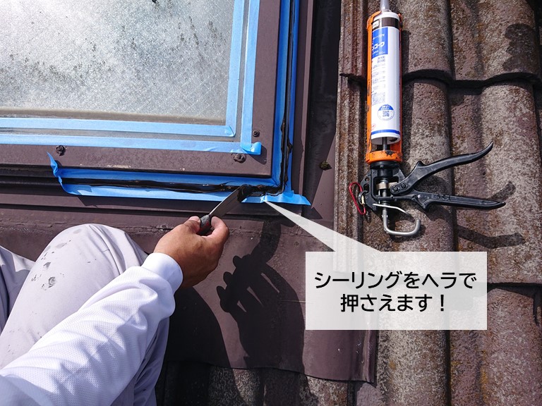 泉大津市の天窓の窓枠の取り合いに充填したシーリングをヘラで押さえます