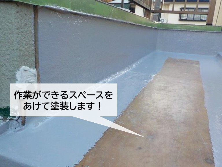 熊取町のベランダ防水のトップコートで作業ができるスペースをあけて塗装します