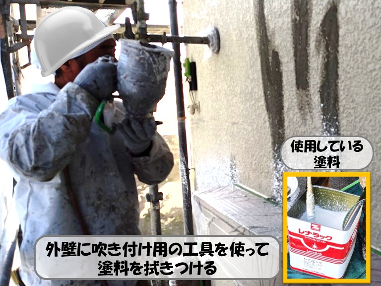 熊取町外壁に塗料を吹き付ける