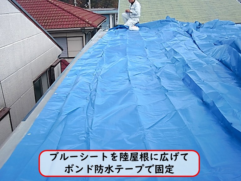 高石市でブルーシートを陸屋根に広げてボンド防水テープでシートを固定