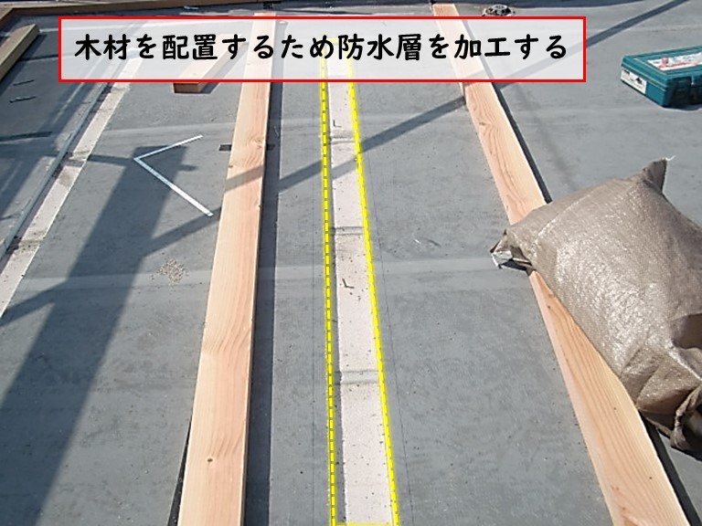 高石市の陸屋根で木材を配置するため防水層を加工する
